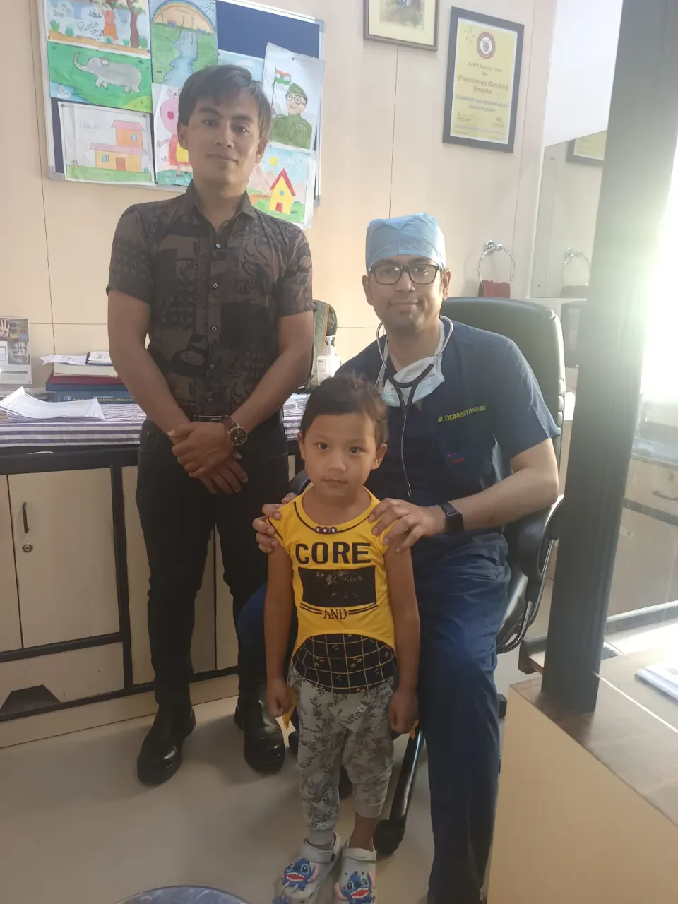Dr. Debabrata Nandi with a young heart patient and parent at his Kolkata clinic